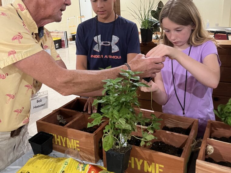 Volunteer Bob Haeuser helps Bo & Evelyn plant herbs