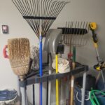 Garden tools properly stored in a garage on a rack