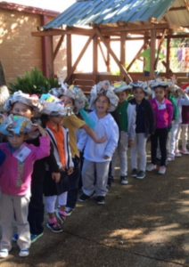 Students lined up with their paper hats on their heads.